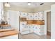 Kitchen with white cabinets, butcher block countertops, white appliances, and tile floor at 323 W Hanna Ave, Tampa, FL 33604