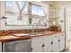Bright kitchen with white cabinets, butcher block counters, and stainless steel appliances at 323 W Hanna Ave, Tampa, FL 33604
