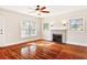 Living room with hardwood floors, fireplace, large windows, and ceiling fan at 323 W Hanna Ave, Tampa, FL 33604