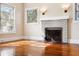 Living room featuring hardwood floors, a white brick fireplace, and ample natural light at 323 W Hanna Ave, Tampa, FL 33604
