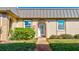 Front view of charming condo with metal roof and well-manicured landscaping at 4235 Stratford Dr, New Port Richey, FL 34652