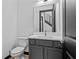 Modern bathroom with white countertop, gray vanity and toilet, and black framed mirror at 6303 Barton Rd, Plant City, FL 33565