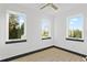 This sunlit bedroom has light wood floors, three windows with black trim, and white walls at 6303 Barton Rd, Plant City, FL 33565