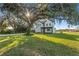 Modern two-story home showcasing a spacious driveway and a large tree at 6303 Barton Rd, Plant City, FL 33565