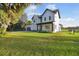 Modern two-story home with mature trees, a green lawn, and partial fencing at 6303 Barton Rd, Plant City, FL 33565