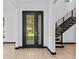 Light-filled foyer with black framed glass door, and modern staircase with wooden steps at 6303 Barton Rd, Plant City, FL 33565
