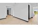 Wide hallway with light wood floors, neutral walls and dark doors leading into other rooms at 6303 Barton Rd, Plant City, FL 33565