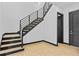Modern staircase with wooden steps and black metal railings near entryway and black door at 6303 Barton Rd, Plant City, FL 33565