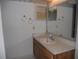 Bathroom with light countertop, wooden cabinets, and a large mirror at 6400 46Th N Ave # 105, Kenneth City, FL 33709