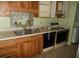 Kitchen with wooden cabinets, sink, oven, and some clutter on the counter at 6400 46Th N Ave # 105, Kenneth City, FL 33709