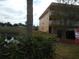 View of the apartment building's exterior with palm trees and a small lake at 6400 46Th N Ave # 105, Kenneth City, FL 33709