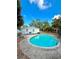 Inviting kidney-shaped pool with concrete decking, set against a backdrop of lush greenery at 6951 19Th N Way, St Petersburg, FL 33702