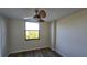 Bedroom with ceiling fan, large window, and wood-look floors at 701 S Madison Ave # 416, Clearwater, FL 33756