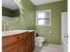 Green bathroom featuring white tile, wooden vanity, and modern fixtures at 9167 108Th St, Seminole, FL 33772