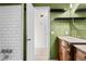 Bathroom with green walls, white tile, and wooden vanity at 9167 108Th St, Seminole, FL 33772