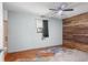 Rustic bedroom with stained concrete floors, wood accent wall, and ceiling fan at 9167 108Th St, Seminole, FL 33772