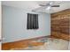 Bonus room with stained concrete floors, wood accent wall, and ceiling fan at 9167 108Th St, Seminole, FL 33772