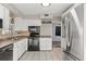 Kitchen with white cabinets, black appliances, and tiled flooring at 9167 108Th St, Seminole, FL 33772