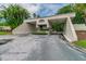 Community entrance gate with lush tropical landscaping and a stop sign at 2700 Cove Cay Dr # 2F, Clearwater, FL 33760