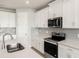 Bright kitchen featuring stainless steel appliances, white cabinets, quartz countertops, and tile backsplash at 11726 Renaissance Blvd, Venice, FL 34293