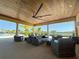 Covered outdoor lounge area with comfortable seating and lake views at 11726 Renaissance Blvd, Venice, FL 34293