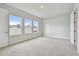 Empty carpeted bedroom with three windows and an entrance door, awaiting your personal touches at 11846 Mile Marsh Dr, Riverview, FL 33569