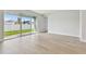 Bright living room with sliding glass doors opening to the green backyard, and light wood floors at 11846 Mile Marsh Dr, Riverview, FL 33569