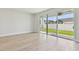 Bright living room with sliding glass doors opening to the green backyard, and light wood floors at 11846 Mile Marsh Dr, Riverview, FL 33569