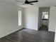 Bright, minimalist bedroom with gray vinyl plank flooring, a ceiling fan, and an ensuite bathroom at 12186 Lamont Dr, Spring Hill, FL 34608
