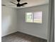This bedroom features new gray vinyl floors, fresh white walls, and a stylish black ceiling fan at 12186 Lamont Dr, Spring Hill, FL 34608