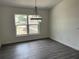 Bright dining room features dark vinyl flooring and a modern chandelier at 12186 Lamont Dr, Spring Hill, FL 34608