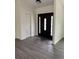 Bright foyer featuring a dark, decorative front door and a convenient coat closet for storage at 12186 Lamont Dr, Spring Hill, FL 34608