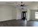 Spacious, open-concept living area with gray vinyl plank flooring and a modern ceiling fan at 12186 Lamont Dr, Spring Hill, FL 34608