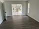 Light-filled living room with sliding glass doors leading to a screened lanai, complete with stylish flooring at 12186 Lamont Dr, Spring Hill, FL 34608