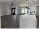 Open living space with gray flooring, sleek lighting, and view of the front entry and island at 12186 Lamont Dr, Spring Hill, FL 34608
