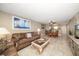 Living room with brown couches, dining area, kitchen access at 1230 Gulf Blvd # 402, Clearwater Beach, FL 33767