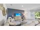 Spacious living room featuring an accent wall, sectional sofa, and glass coffee table at 17451 Whiskey Creek Trl, Parrish, FL 34219