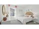 Bright bedroom with white and coral accents, wicker headboard, and large window at 17463 Whiskey Creek Trl, Parrish, FL 34219