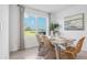 Dining area with natural light, a wooden table, and wicker chairs overlooking the backyard at 17463 Whiskey Creek Trl, Parrish, FL 34219