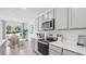 Kitchen with gray cabinets, stainless steel appliances, white countertops, and dining area at 17463 Whiskey Creek Trl, Parrish, FL 34219