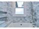 Renovated bathroom with marble tile and a bathtub at 205 W Emma St, Tampa, FL 33603