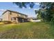 House's back elevation showcasing a screened patio and spacious backyard at 2212 Valterra Vista Way, Valrico, FL 33594