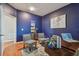 Bright home office with navy walls and wood floors, featuring a desk and two chairs at 2212 Valterra Vista Way, Valrico, FL 33594