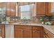 Kitchen features a double sink, granite countertop, and wood cabinets at 2212 Valterra Vista Way, Valrico, FL 33594