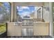Outdoor kitchen with stainless steel grill, built-in cabinets, and granite countertops at 2212 Valterra Vista Way, Valrico, FL 33594