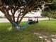 Serene backyard oasis with a hammock and hanging chairs by the lake at 2765 Mauritania Rd, Punta Gorda, FL 33983