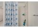 Bathroom with a shower/tub, white subway tile, and a blue floral shower curtain at 31451 Moniker Mast Ln, San Antonio, FL 33576