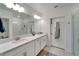 Modern bathroom with double vanity, quartz countertop and large mirror at 31451 Moniker Mast Ln, San Antonio, FL 33576