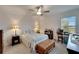 Bright bedroom with a queen-size bed, ceiling fan, and a workspace setup at 31451 Moniker Mast Ln, San Antonio, FL 33576