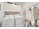 Bright laundry room, washer, dryer, and ample storage cabinets at 31451 Moniker Mast Ln, San Antonio, FL 33576
